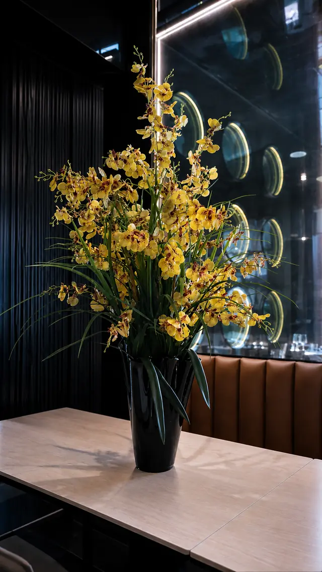 Orchidee gialle in vaso nero sul tavolo