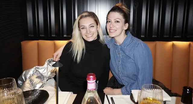 Due ospiti sorridenti sedute sul divanetto in pelle